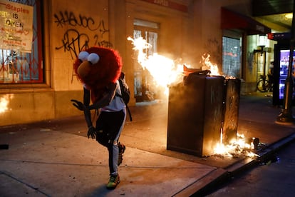 Un manifestante con una máscara de Elmo huye de un incendio callejero el 30 de mayo de 2020, durante una protesta en Filadelfia por la muerte de George Floyd. En un vídeo que se hizo viral, Derek Chauvin, un oficial blanco de 44 años inmovilizó a Floyd hasta dejarlo sin respiración. Este hecho desató protestas contra el racismo y el abuso policial en distintas ciudades de Estados Unidos.