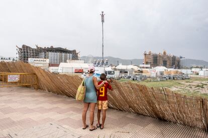 Una madre junto a su hijo observan este sábado la estructura del festival Medusa, después de que se derrumbase parte del escenario principal durante la madrugada.