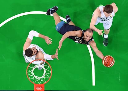 El argentino Manu Ginobili (centro) intenta tirar a canasta rodeado de los lituanos Jonas Valanciunas (izquierda) y Marius Grigonis (derecha). 