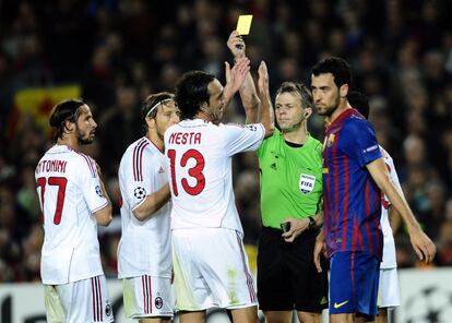 El árbitro, Bjorn Kuipers, muestra la cartulina amarilla a Nesta tras señalar penalti sobre Busquets