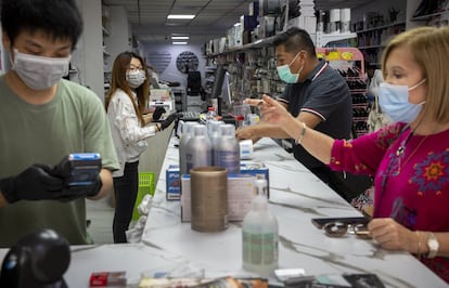 Dos empleados atienden a clientes, en una tienda de venta de cosméticos, en Valencia. 