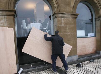 Un comerciante protege los ventanales de un restaurante en San Sebastián.