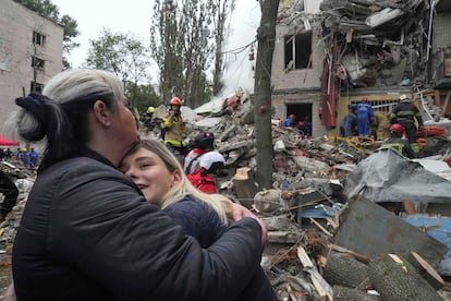 Dos mujeres se abrazan en los aledaños del edificio destruido por el ataque ruso en Kiev este jueves.