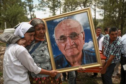 Dos mujeres sostienen un retrato del jesuita Javier Campos Morales, durante una procesión fúnebre en su honor y el de su compañero sacerdote, Joaquín César Mora Salazar, en Cerocahui, Estado de Chihuahua, el 26 de junio. Los dos sacerdotes y un guía turístico asesinados en la sierra Tarahumara forman parte de una larga lista de activistas, reporteros, viajeros y residentes que han sido amenazados o asesinados por las bandas criminales que dominan la región.