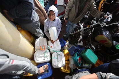 A boy looks on as Palestinians gather to buy fuel during a temporary truce between Hamas and Israel, in Rafah, on November 25.