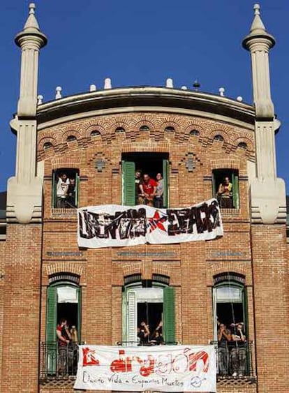 Los jóvenes muestran sus pancartas en el edificio recién ocupado.