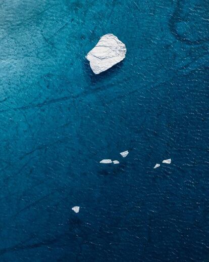 Um fragmento de iceberg flutua em um lago de água proveniente do derretimento do Ártico.