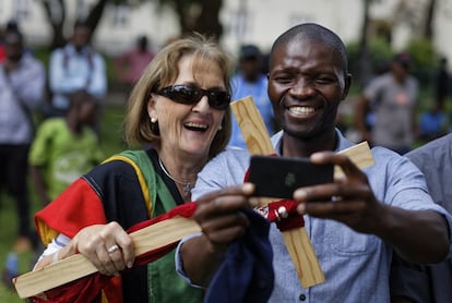 Dos zimbabuenses se sacan un selfie durante la concentración cristiana el 20 de noviembre para rezar por la paz en Harare (Zimbabue). 
