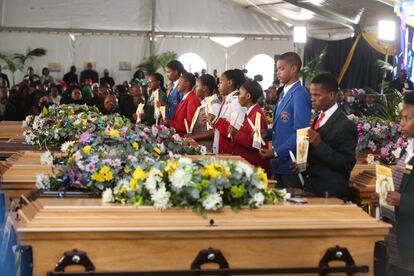 Un grupo de jóvenes vela los ataúdes de los fallecidos en la taberna Enyobeni en el funeral por las víctimas celebrado en East London, Sudáfrica, el 6 de julio de 2022.