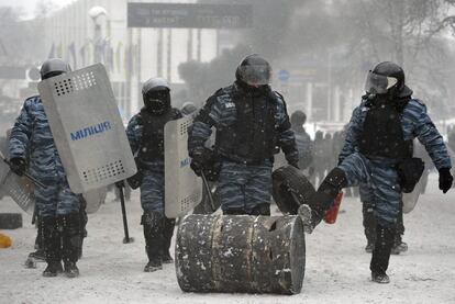 Varios policías retiran una barricada durante la protesta en el centro de Kiev (Ucrania) que comenzó el domingo 19 de enero. 