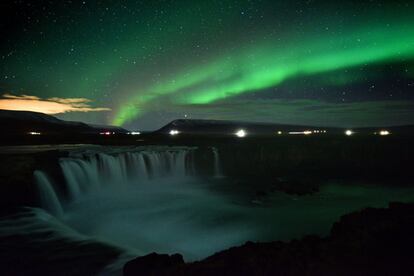 La aurora boreal, también conocida como 'Northern Lights', en la cascada de Godafoss, en el municipio de Thingeyjarsveit (Islandia).