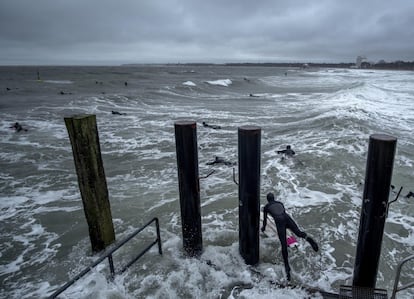 Un surfista salta al Mar Báltico azotado por una tormenta en la playa deTimmendorf (Alemania).