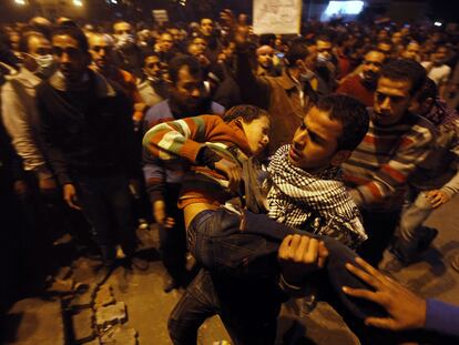 Un manifestante traslada a un joven herido durante los enfrentamientos con las fuerzas antidisturbios en la plaza de Tahrir.