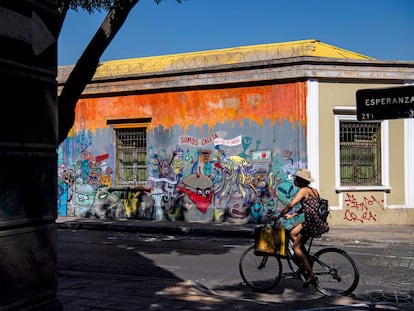 Una mujer pasea en bicicleta por el barrio de Yungay, un barrio tradicional y bohemio del centro de Santiago donde vivirá el presidente Gabriel Boric.