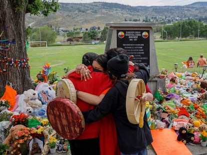 Miembros de la comunidad Mosakahiken Cree Nation se abrazan frente a un monumento en homenaje a las 215 tumbas de niños halladas en el antiguo internado Kamloops para indígenas en Columbia Británica, Canadá, el pasado 4 de junio.