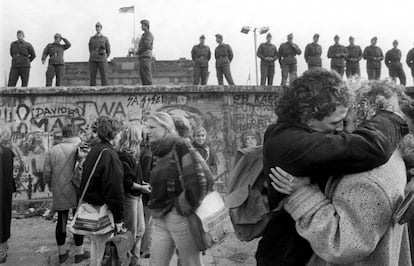 El bloqueo fronterizo del muro de Berlín acabó el 9 de noviembre de 1989. Aunque físicamente la piedra, el ladrillo y el cemento tardaron algo más en romperse, ese día terminó la separación entre el Berlín del Este y del Oeste. En esta imagen una pareja se besa a los pies de la pared. Alrededor, jóvenes se acercan al Muro para contemplar el fin de la división el 15 de noviembre de ese año.