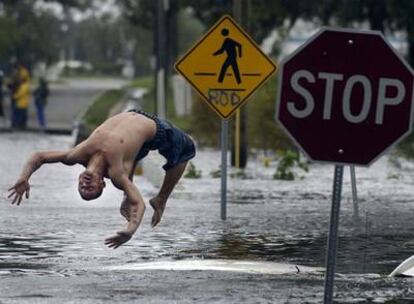 El joven Jason Redden salta desde el tejado de un coche sumergido en una calle inundada de Jacksonville, Florida. Redden afirma haber rescatado a la conductora, que quedó atrapada en su vehículo al adentrarse en la calle sumergida