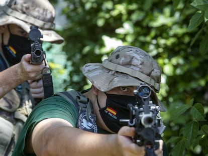 Dos alumnos del campamento de orientación militar Don Pelayo apuntan con sus armas de 'airsoft', réplicas de armas reales.