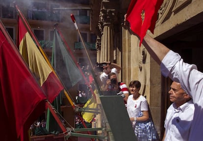 El veterano pamplonés Jesús Ilundain Zaragüeta (d), 'El Tuli', promotor del cántico a San Fermín previo al encierro en los años 50 y elegido por primera vez en una votación popular, durante el lanzamiento del chupinazo desde el balcón del Ayuntamiento de Pamplona.