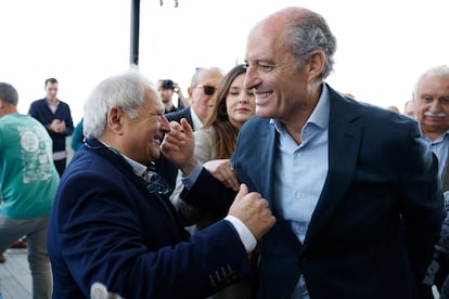 Francisco Camps saluda al expresidente de la Diputación de Valencia Alfonso Rus, a su llegada a un acto celebrado este sábado en Valencia. Al fondo y en el centro, Carlos Fabra.