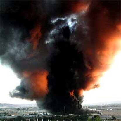 Una densa columna de humo asciende desde el interior de la fábrica incendiada en Arganda.