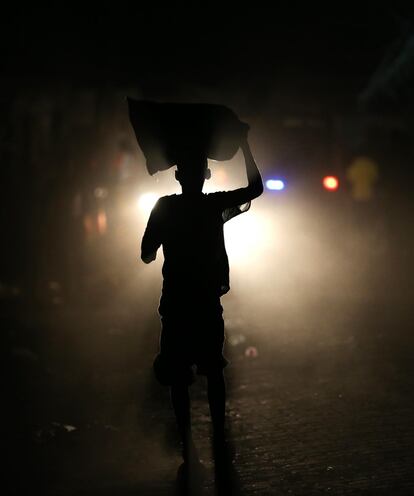 Un hombre camina por una calle sin iluminación debido a un fallo del servicio eléctrico tras el paso del huracán Matthew.