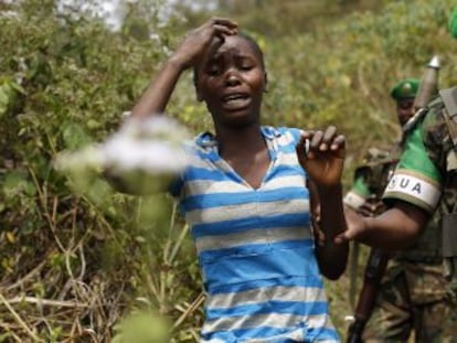 Uma mulher aterrorizada é conduzida por um soldado nos arredores de Bangui, capital da República Centro-Africana.