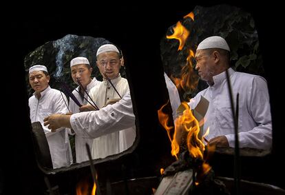 Imãs muçulmanos chineses rezam segurando palitos de incenso na mesquita de Niujie em Pequim (China), em 4 de julho de 2014.