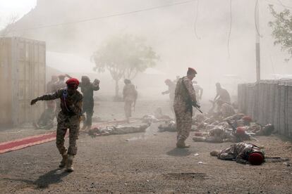 Varios soldados permanecen en el suelo tras el ataque de un misil durante un desfile de graduación militar celebrado en Aden (Yemen).