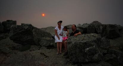 Mara Jess, su marido y su hijo peque?o, el pasado 13 de julio en una parada de camino a la Pe?a de Francia, mirador desde el que se poda ver la lnea de avance del incendio. El humo tapaba el sol convirtindolo en una enorme bola roja. La familia es de Nava de Francia, un pueblo cercano, que no ha sido afectado por las llamas.