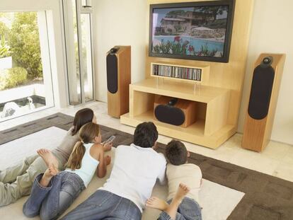 Una familia ve una película en el salón de casa.