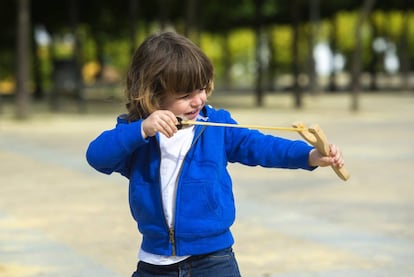 Un niño jugando con un tirachinas