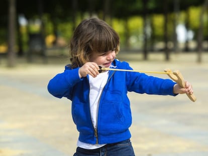 Un niño jugando con un tirachinas