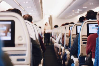 Vista interior de la clase turista en la cabina de un avión.