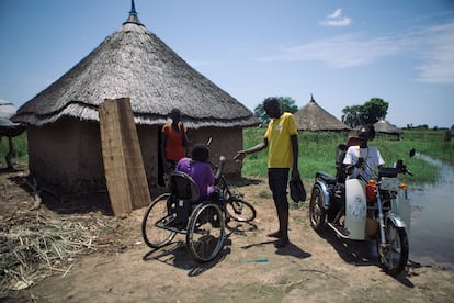 Al menos una de cada seis personas de Sudán del Sur sufre alguna discapacidad, según Light for the World, una ONG que defiende los derechos de los discapacitados, uno de los colectivos más vulnerables a los embates del clima. En la fotografía, Majok John, de 40 años, responsable de inclusión de Light for the World, visita a Mach Garang, de 35 años. La organización le entregó un triciclo para facilitarle la movilidad y la evacuación en caso de peligro por inundaciones.