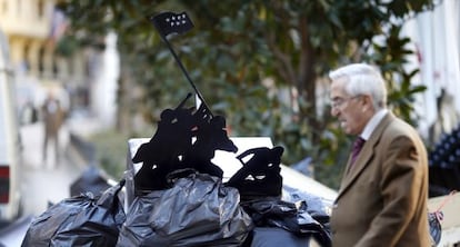 Basura acumulada en las calles durante la huelga de limpieza viaria, con una alusión al alzamiento de la bandera estadounidense en Iwo Jima.