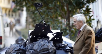 Basura acumulada en las calles durante la huelga de limpieza viaria, con una alusi&oacute;n al alzamiento de la bandera estadounidense en Iwo Jima.