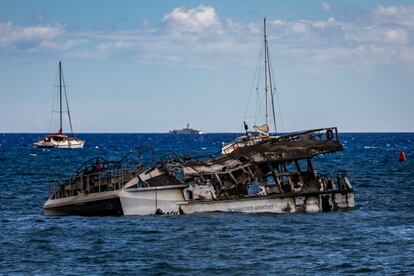 Un catamarán dañado por el incendio de Maui flota frente a las costas de Lahaina (Hawái).
