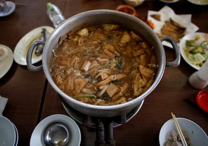 Una olla contien 'Chanko nabe', un plato típico de pie de cerdo, sardinas fritas, arroz y un potaje especial ultracalórico.