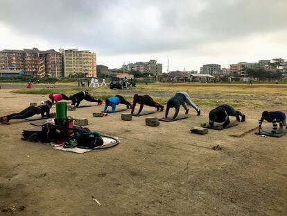 Media docena de miembros del 'Team Tina' hace flexiones en el espacio al aire libre habilitado como gimnasio en el barrio de Tena, en Nairobi, Kenia.