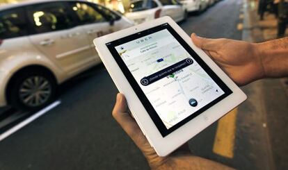 Un usuario de Uber consulta la aplicación en Valencia ante una parada de taxis.