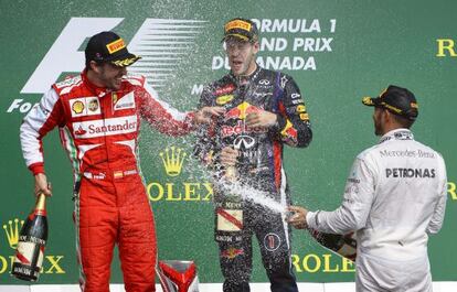 Hamilton moja a Alonso y a Vettel con champán en el podio.