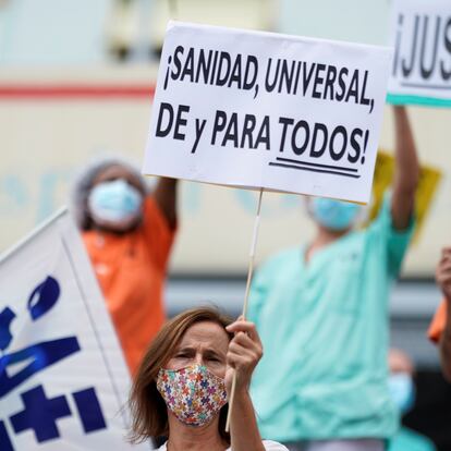 A health worker holding a placard reading "Universal healthcare for all" attends a protest against the regional health authority's lack of support and demanding better working conditions outside Gregorio Maranon hospital in Madrid, Spain September 15, 2020. REUTERS/Juan Medina
