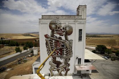 Nychos, subido en una grúa dibuja los esqueletos de la pared más alta del silo, de unos 30 metros de altura.