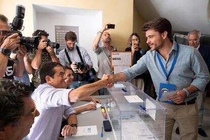 El candidato del PP a la alcaldía de Sevilla, Beltrán Pérez, saluda al presidente de la mesa electoral tras depositar su voto, acompañado por el portavoz adjunto del GPP en el Senado, Javier Arenas.