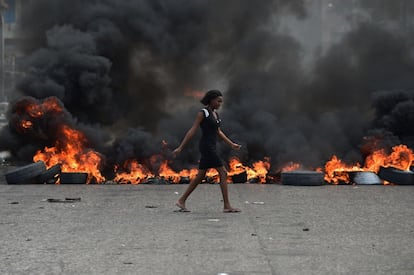 Una mujer pasa junto a una barricada durante la cuarta jornada de protestas en Puerto Príncipe, el 10 de febrero de 2019.