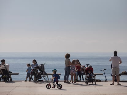 Familias pasean por el paseo marítimo de Barcelona.