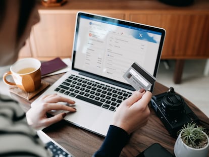 Una mujer compra boletos de avión en el portal web de una aerolínea.