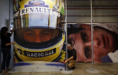 Operarios cuelgan fotos del brasileño Ayrton Senna en una exposición conmemorativa en la pista de carreras de Imola (Italia) en 2014.