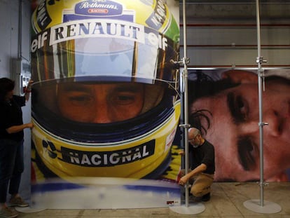 Operarios cuelgan fotos del brasileño Ayrton Senna en una exposición conmemorativa en la pista de carreras de Imola (Italia) en 2014.